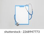 Blank clipboard with stethoscope on grey background. World Health Day