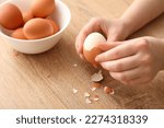 Woman peeling boiled egg on...