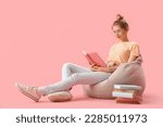 Young woman reading book on...