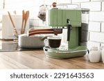 Modern coffee machine with cup of espresso on wooden kitchen counter
