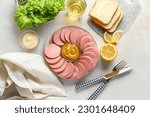 Plate with tasty sliced boiled sausage, bread and sauces on light background