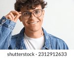 Young man in stylish eyeglasses on light background, closeup
