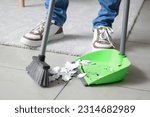 Small photo of Young man sweeping floor with broom at home, closeup