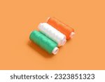 Indian flag made of thread spools on orange background