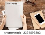 Small photo of Woman with newspapers on wooden background