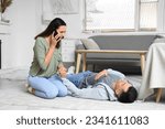 Small photo of Young woman calling ambulance while her husband having heart attack at home
