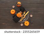 Halloween table setting with tasty cookie on dark wooden background