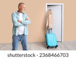 Mature woman with suitcase leaving her husband at door. Divorce concept
