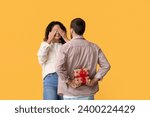 Man greeting his girlfriend with Valentine's day on yellow background