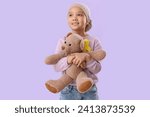 Cute little Asian girl after chemotherapy with yellow ribbon on lilac background. Childhood cancer awareness concept