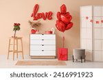Interior of living room with chest of drawers and decorations for Valentine's Day celebration near beige wall