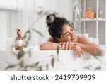 Young African-American woman taking bath at home