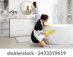 Young chambermaids cleaning in bathroom