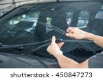 Man is changing windscreen wipers on a car