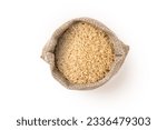 Small photo of Coarse brown rice in sack bag isolated on white background, top view, flat lay.