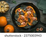 Small photo of Rustic cast iron skillet with pumpkin pancakes on a wooden table with harvest of pumpkins on the side.