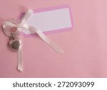 Above View of a Cute, Pink and White Notecard for a Baby Girl on Pink Cloth Background with room or space for copy, text, your words.  A Silver Heart shape Teething Ring. Horizontal looking down