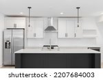 Small photo of OAK PARK, IL, USA - JUNE 12, 2022: A renovated kitchen with a dark grey island, marble countertops, stainless steel appliances, and a white herringbone backsplash.