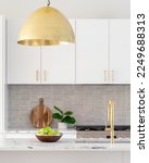 Small photo of A kitchen detail with white cabinets, gold faucet and light hanging over the island, and a tiled backsplash.