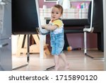 Small photo of Baby standing on tiptoes.cute boy learning how to walk first step at home.mixed race Asian-German infant about 10-11 months old.