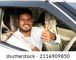 Happy cab driver with showing thumbs up after wearing car seat belt by looking at camera - concept of safety measures, recommendation and protection