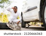 Cab or car driver changing punctured taxi wheel on roadside while travelling - concept of bad luck, problems, backup and safety