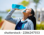 Small photo of Thirsty woman drinking water from bottle after workout at park - concept of hot determination, heat wave and active lifestyle