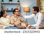 Small photo of Indian doctor consoling senior couple by giving confidence while sitting on sofa at home - concept of mental illness, health care support and assistance