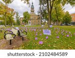 Small photo of Hillsdale, Michigan, USA - October 21, 2021: The Hillsdale County Courthouse with flags and signs promoting Domestic Violence Awareness