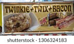 Small photo of Matthews, North Carolina September 2, 2018 - Sign for deep fried Twinkie+Twix+bacon at a street festival