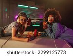 Small photo of Two diverse stylish girls are eating takeout food at the drive thru.