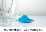Small photo of Closeup inorganic chemical on white laboratory table. Copper(II) sulfate in Chemical Watch Glass place next to alcohol liquid in Beaker. Chemical ingredient for Cosmetics and Toiletries product.