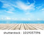 Wooden floor with blue sea and sky background 