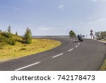 Biker on dangerous and winding road in the high mountains