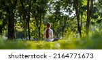 Small photo of Woman relaxingly practicing meditation yoga in the forest to attain happiness from inner peace wisdom with beam of sun light for healthy mind and soul