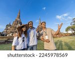 Small photo of Thai local tour guide is explaining the history of old Siam to the couple of tourist on their backpacker honeymoon travel to ancient temple of Ayutthaya, Thailand