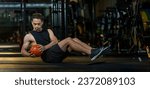 Small photo of Asian man is workout in gym doing seated oblique twist exercise with weight medicine ball on floor which strengthen the abs abdominal and the core body muscle