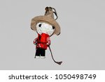 Small photo of Bogeyman cowboy holds lasso in both hands on bright background.