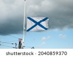 Small photo of The St. Andrew's flag is flying in a strong wind. The St. Andrew's Banner is a symbol of naval military forces. White cloth with a diagonal cross of blue color
