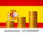 Small photo of Upgoing graph made of coins stacked in front of Spain flag. Concept of financial development of Spain