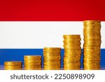 Small photo of Coins forming upgoing graph near flag of Netherlands. Economic and financial growth of Netherlands