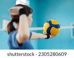 Small photo of Young girl player preparing to serve the volleyball to opponents side of the net. Female learner mastering skills in volleyball, practice serving