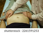 Small photo of visceral abdominal massage for a young woman, Osteopathic Manipulation and CranioSacral Therapy. Non-traditional medicine. Health care