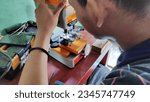 Small photo of Locksmith working on the duplicate of a key in the duplicating machine, Batang Indonesia ‎August 9 ‎2023