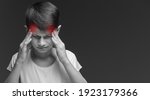 Small photo of boy on grey background suffering from headache desperate and stressed because pain and migraine. Hands on head. headache in children. overload at school. pronounced red pain points on the head