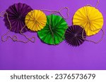 Small photo of Festive Mardi Gras masquerade purple background. Fat Tuesday carnival, beads, traditional decor. Symbolic colors, trendy hard light, dark shadow, flat lay, top view