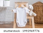 White baby short sleeve bodysuit mockup for presentation cute sublimation designs. Minimalistic photos of romper for toddlers in scandinavian interior with minimalistic decoration