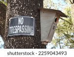 No Trespassing Sign posted on Tree with Wooden Bat House.