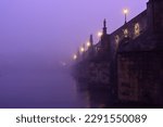 Charles Bridge on Vltava River in Prague Old Town. Early morning. Heavy fog.