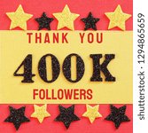 Small photo of Thanks 400000, 400K followers. message with black shiny numbers on red and gold background with black and golden shiny stars for social network friends, followers, likes